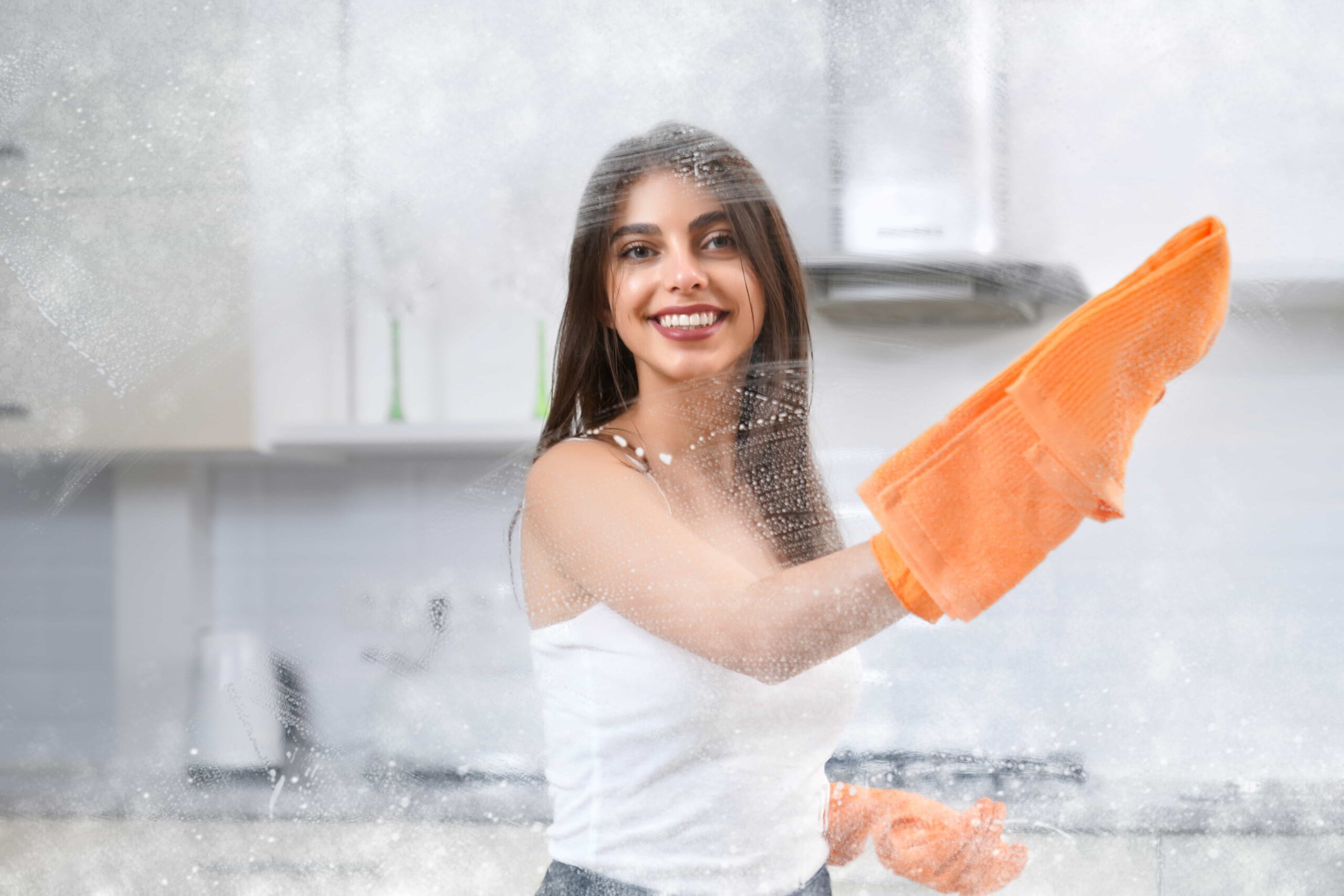 smiling-woman-washing-window-with-rag-min (1)